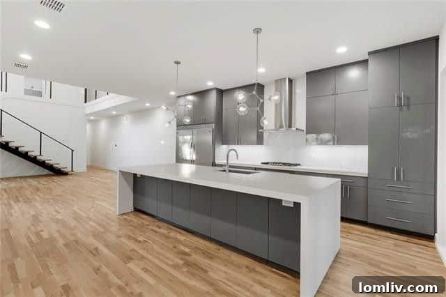 Gourmet kitchen with large waterfall quartz island and modern fixtures