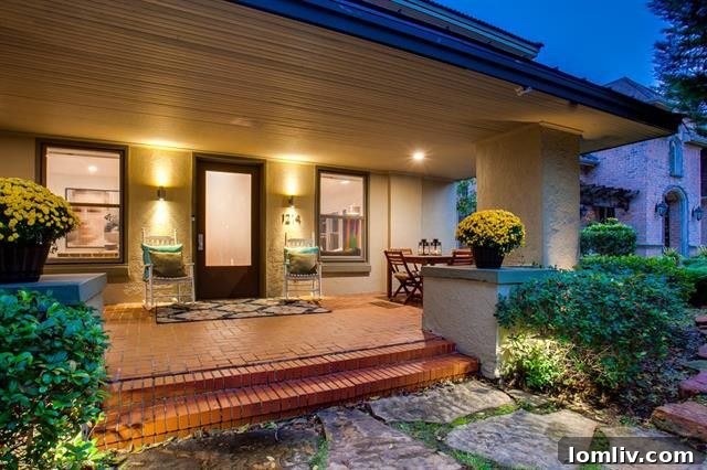 Grand front porch of the Prairie-style home at 1214 N. Clinton Ave, framed by lush gardens