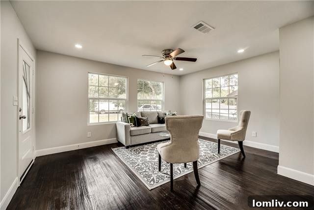 Spacious open-concept living area with hardwood floors and bright walls