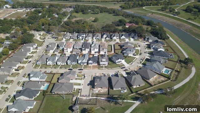 Overlooking the Trinity River, showing a beautiful home in the River Heights community with lush greenery and easy access to the trails.