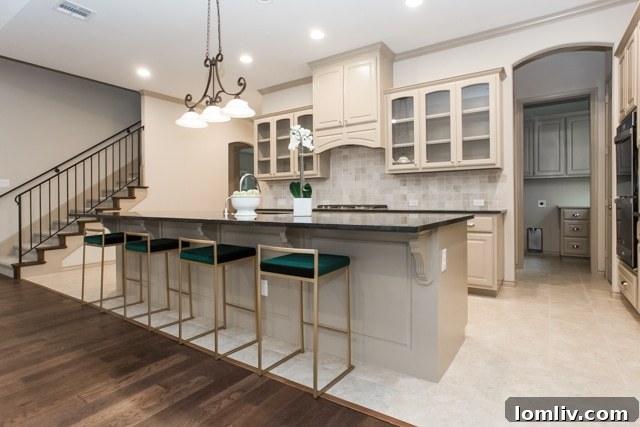 Interior view of a modern open-concept kitchen with glass-front cabinetry, double ovens, and expansive counter space, characteristic of homes in River Heights.