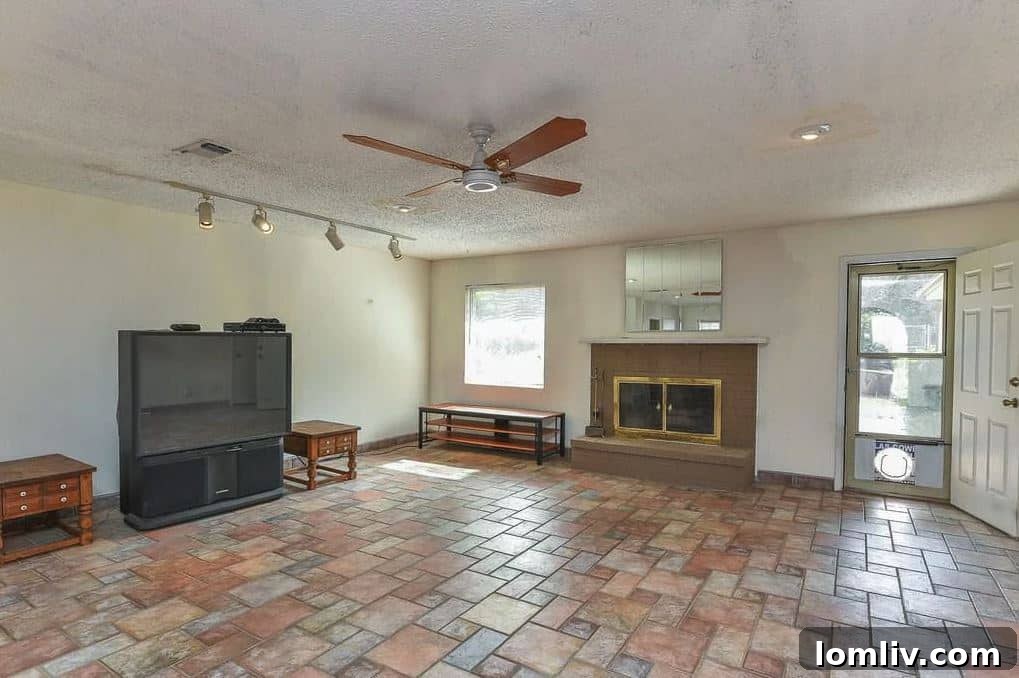 Before renovation living area with older carpet and fireplace