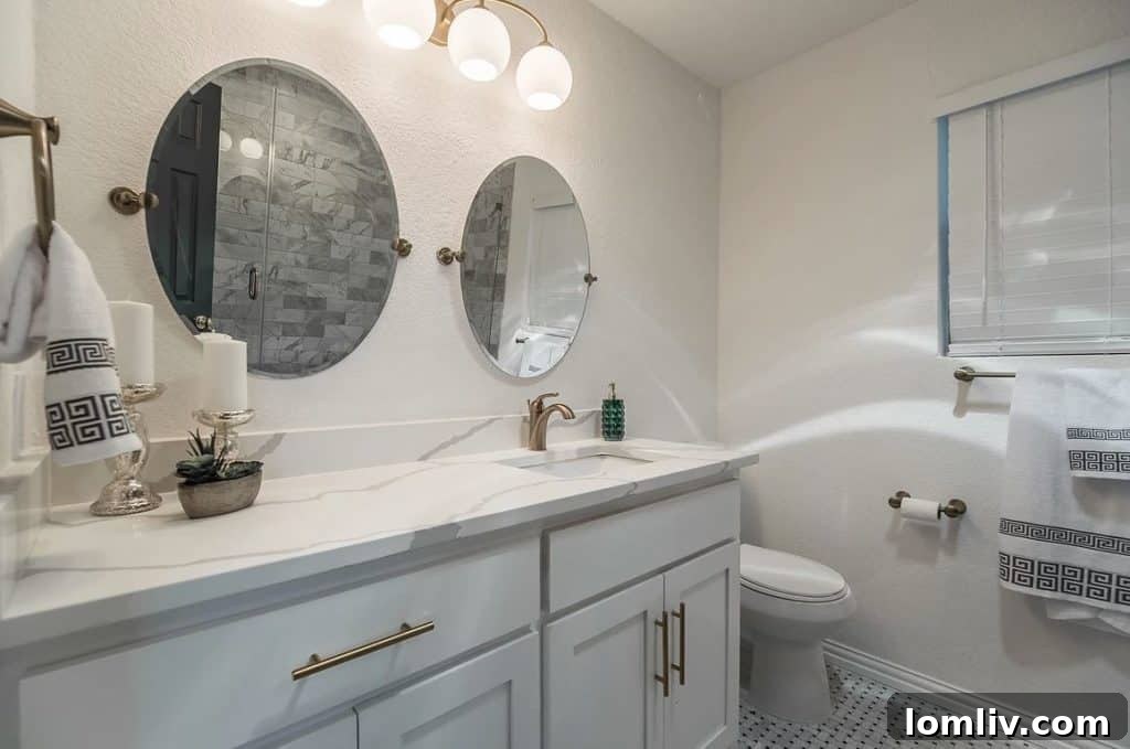 Elegant master bathroom with marble tile and designer lighting