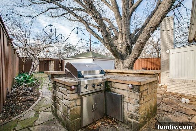 Expansive backyard with stone patio and built-in grill at 10111 Champa Drive