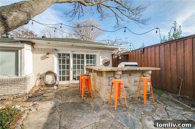 Al fresco dining area under cafe lights in the backyard of East Dallas home