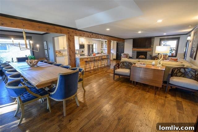Open-concept living and dining space with exposed beams and hand-scraped hardwoods in 10355 Cary Back Circle, ideal for entertaining.