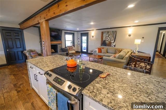Cozy living room featuring a stacked-stone fireplace and direct access to the inviting outdoor patio.