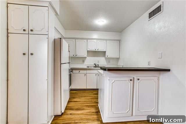 Overview of the open-concept living space extending towards the kitchen in a modern Dallas condo rental, highlighting the seamless flow.