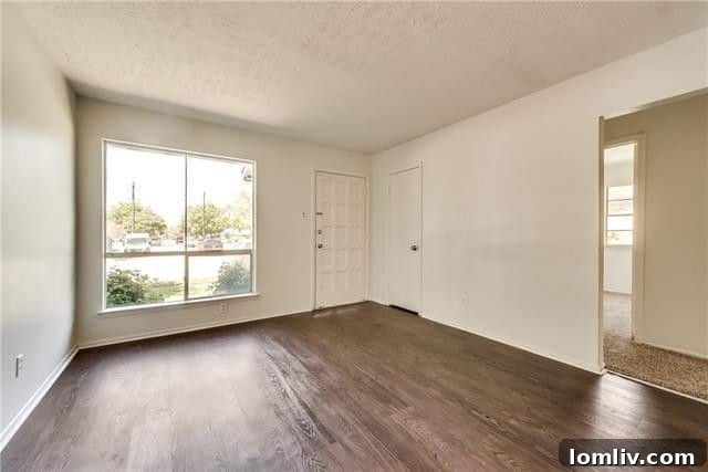 Bright and spacious living area with new luxury vinyl flooring and fresh paint, showing an inviting atmosphere