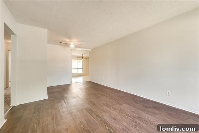 Spacious backyard with a large grassy area, mature trees, and a covered patio, perfect for outdoor entertainment