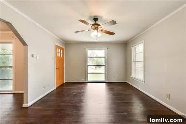 Interior view of a living space with refinished hardwood floors and ample natural light, showcasing the classic yet updated aesthetic of the Dells District home