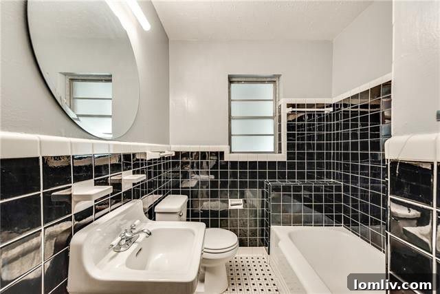 Bathroom showcasing original, well-maintained tile work that offers a charming vintage appeal, ready for a modern update by the new homeowner