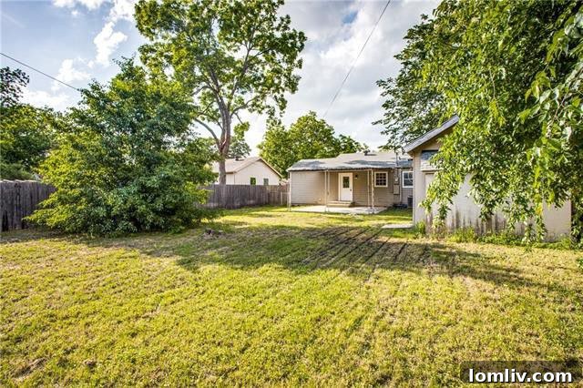 Spacious backyard with a shed and mature trees at 8232 Rayville Drive Dallas