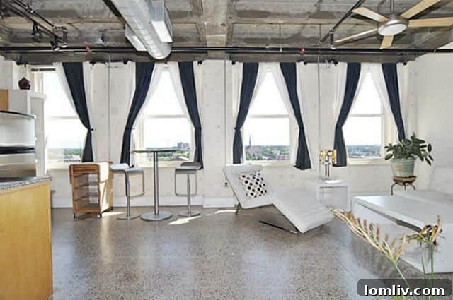 Interior of a Texas & Pacific Loft, showing an open concept living space with exposed brick and large windows.