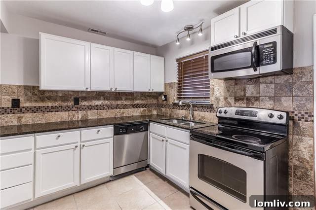 Contemporary kitchen featuring new white cabinetry, granite counters, and stainless steel appliances