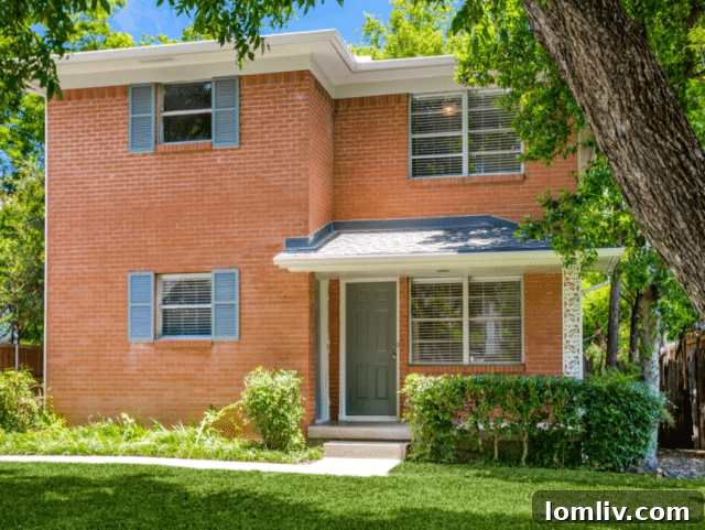 Remodeled kitchen with white cabinets, stainless steel appliances, and new tile floor in a North Oak Cliff duplex unit