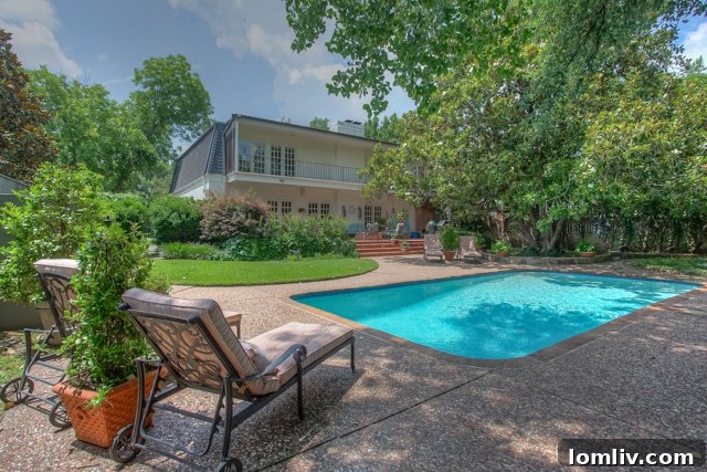 Elegant swimming pool with lush landscaping and outdoor seating in a luxury Fort Worth backyard
