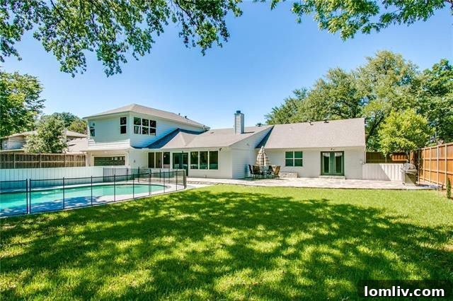 Fenced swimming pool and lush backyard in a spacious Hockaday property