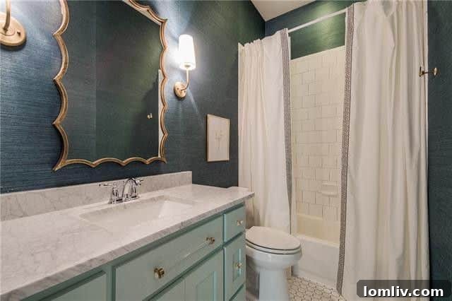 Stylish guest bathroom with navy grasscloth wallpaper and unique mirror