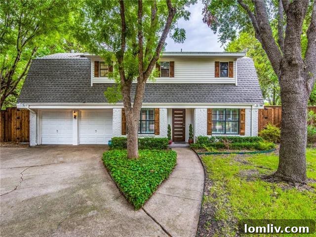 Stunning curb appeal of a renovated four-bedroom home in Farmers Branch, Texas, featuring charming brick facade and lush landscaping.