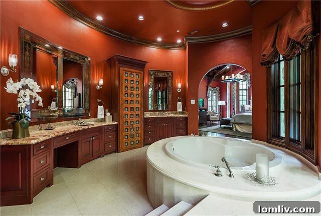The luxurious marble spa bath in the master suite of 5019 Shadywood Lane, featuring dual vanities, a jetted tub, and a double steam shower.