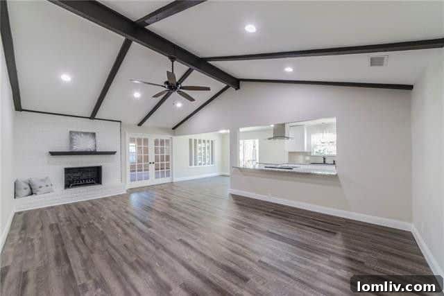 Open concept living area with fresh flooring and wooden beams