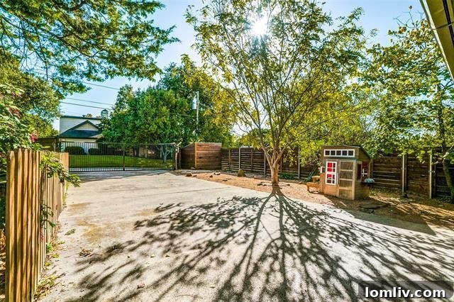 Spacious backyard lawn with mature trees and privacy fencing
