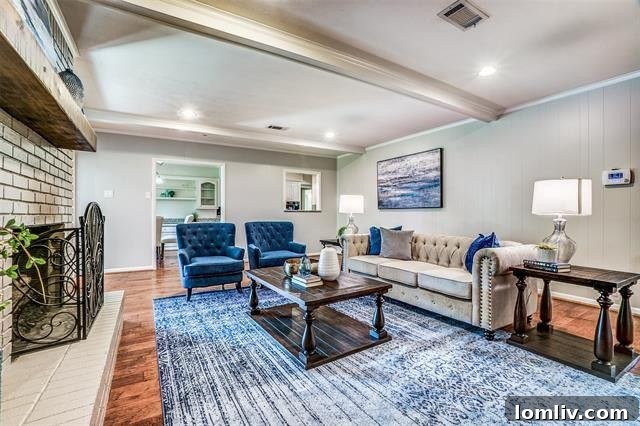 Cozy family den with a gray brick gas log fireplace and beamed ceiling