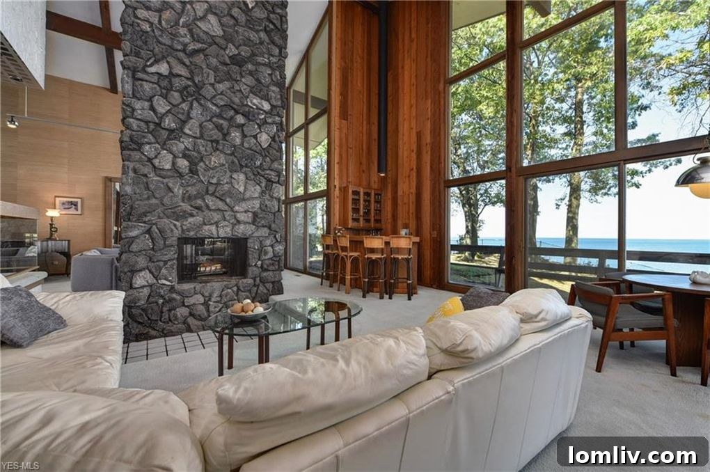 Spacious Living Room with a Grand Stone Fireplace and Lake Views