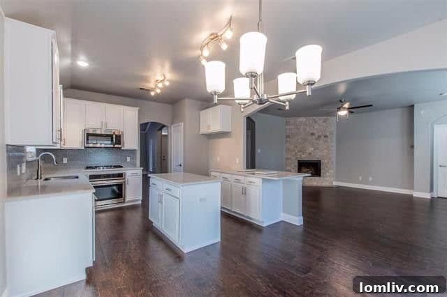 Interior view of a modern kitchen with a large island, stainless steel appliances, and subway tile backsplash in a Rockwall home.