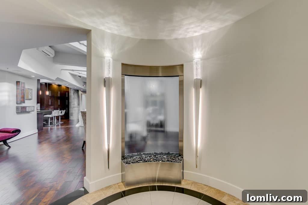 Luxurious penthouse foyer featuring a stunning glass waterfall art installation and a glimpse of the extensive wine cellar.