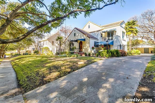 Charming Mediterranean facade of 2228 Wilshire Boulevard with blue awnings and lush landscaping