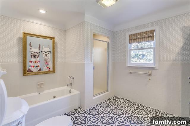 Luxurious master bedroom with sitting area, wood-burning fireplace, and tasteful decor