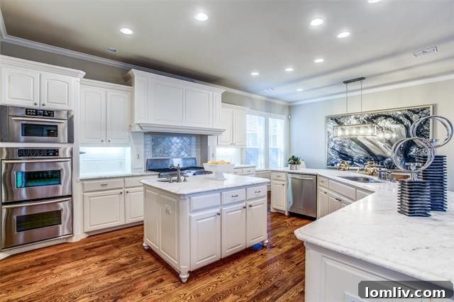 Gourmet kitchen with white cabinets, Carrera marble, and stainless steel appliances in 5345 Goodwin Ave