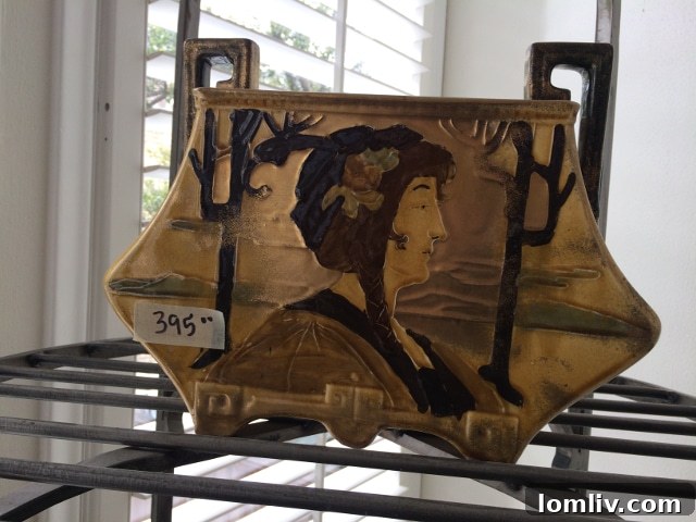 Intriguing artistic vase with detailed figures, possibly depicting a scene of cultural significance, with a background suggesting either desert or ancient landscapes