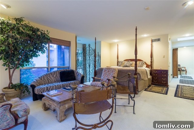 Grand master bedroom showcasing a king-size mahogany four-poster bed, ample space, and one of two fireplaces in Unit 2B
