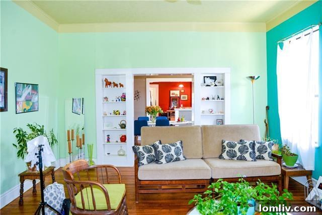 Vibrant living room with lime sherbet walls, a turquoise fireplace, and original hardwood floors