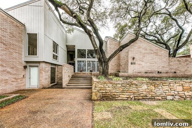 8111-Windy-Terrace, a stunning modern home exterior with lush landscaping.