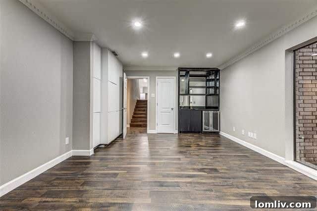 Spacious home office featuring a wet bar, built-in shelving, and a large picture window.