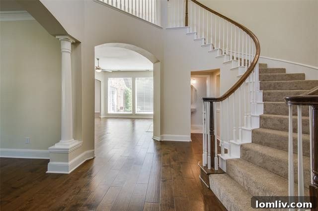 Grand two-story foyer with a curved staircase and elegant architectural details in a Dallas traditional home