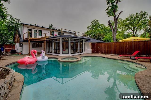 Expansive swimming pool and spacious patio area in the backyard, ideal for summer relaxation and outdoor gatherings