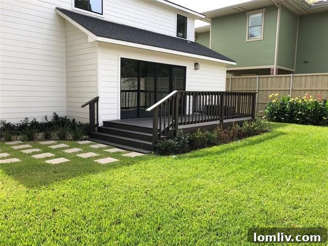 Expansive wooden deck and manicured grassy lawn with vibrant flowerbeds, perfect for outdoor entertaining