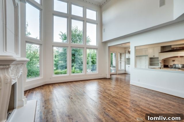 Spacious living room with large windows offering lake views at 6912 Hill Forest Drive