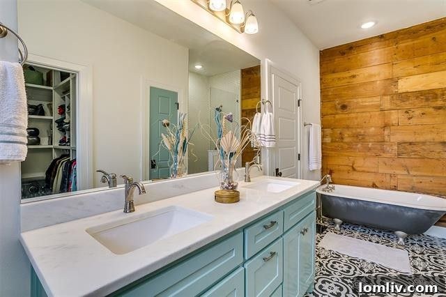 Luxury primary bathroom with double sinks, walk-in shower, and claw-footed tub