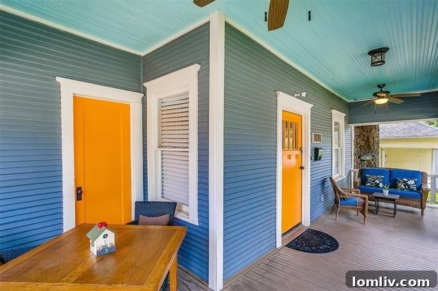 Vibrant exterior of a 1921 Fairmount bungalow with blue siding and orange doors