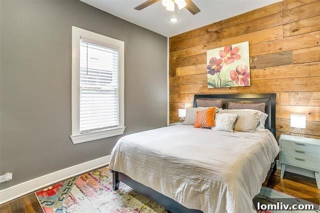 Serene downstairs primary bedroom suite with accent wall in Fairmount home