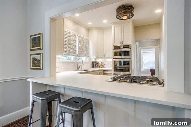 Renovated kitchen with stainless steel Jenn-Air appliances and white cabinetry
