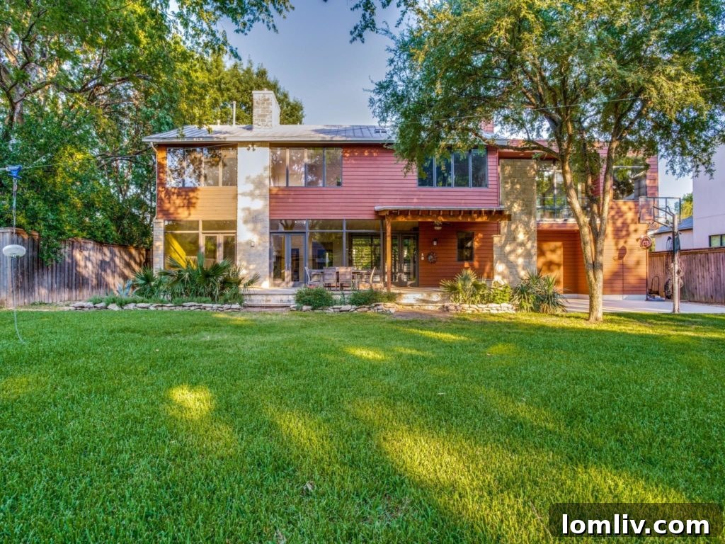 View from the backyard showcasing the home's inviting outdoor fireplace and covered patio
