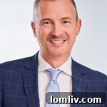 Steve Killingback, a dapper real estate agent, smiles confidently.