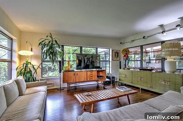 Screened patio, described as a fourth living area, with modern gas fireplace and rugs